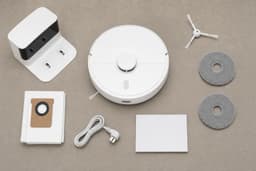 Conținutul pachetului — robot, stație, perie laterală, lavete, sac de praf, cablu, manual